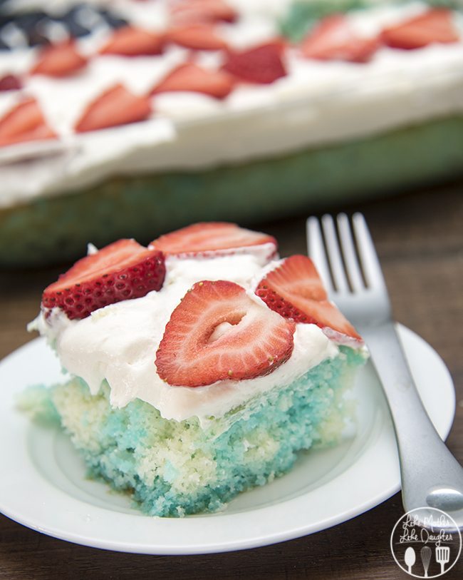 Red White and Blue Jello Poke Cake on a white plate with a fork.