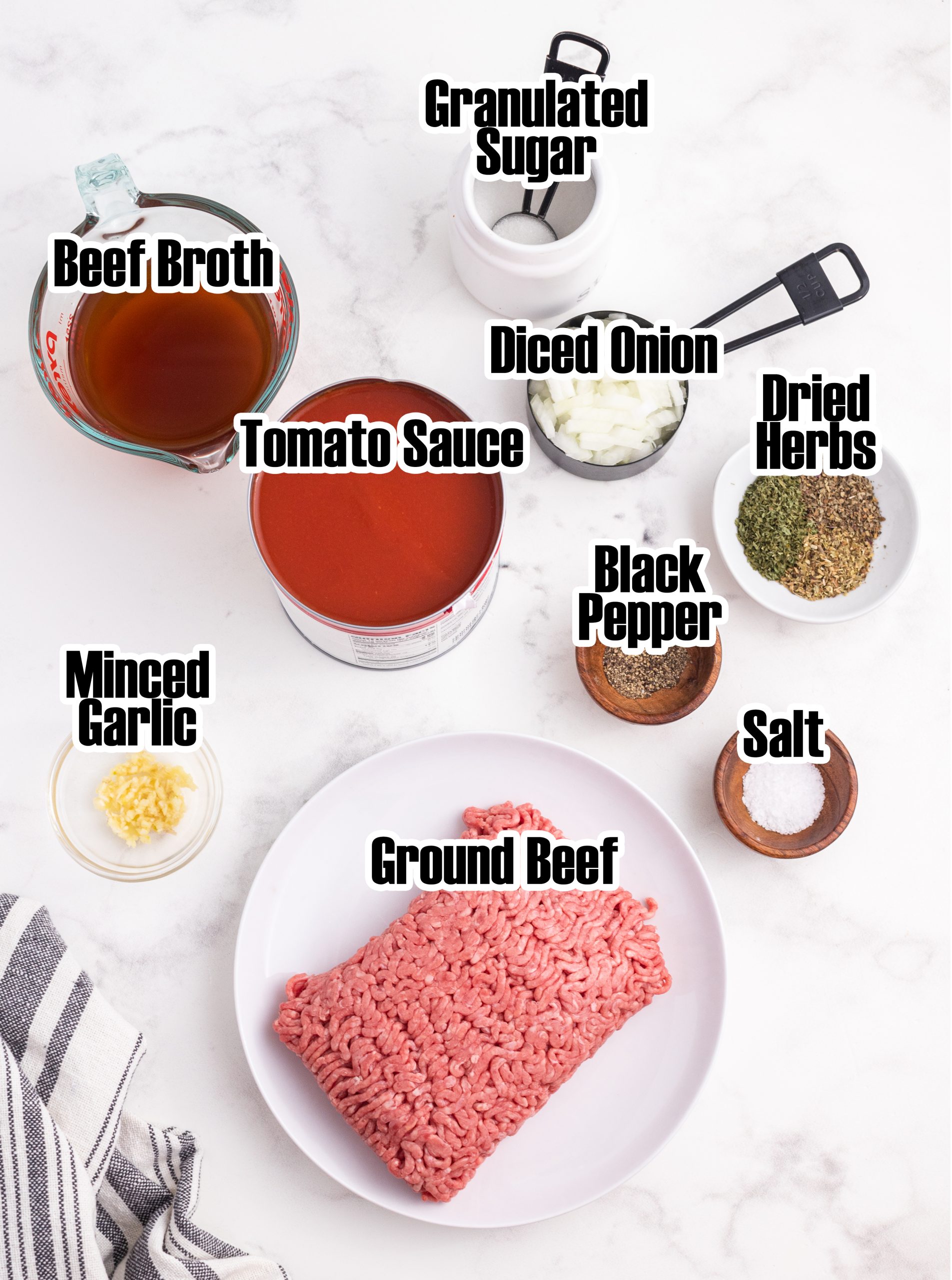 An overhead photo of the ingredients needed to make spaghetti sauce with text labels on each of them. 
