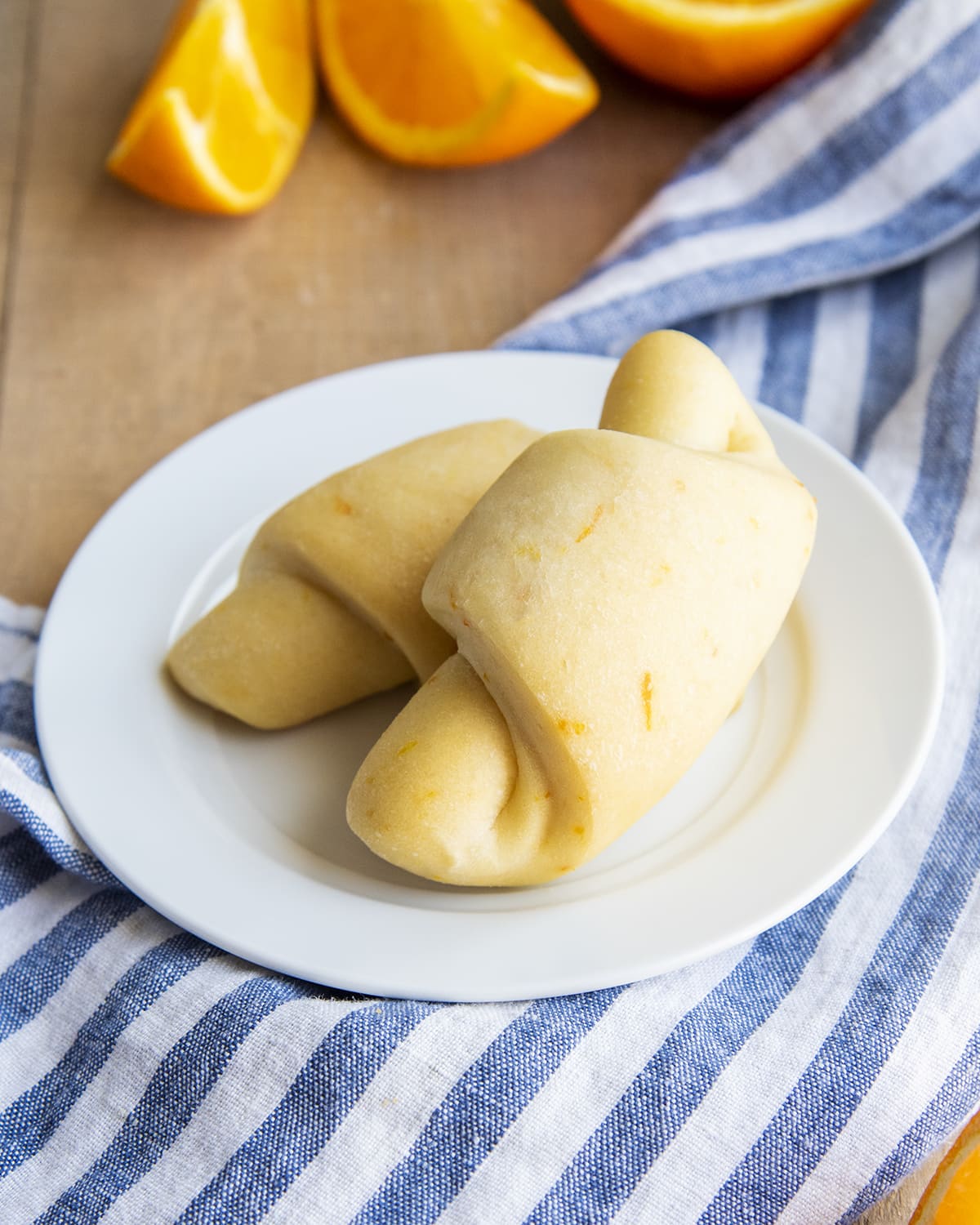 Two orange crescent rolls on a small plate.