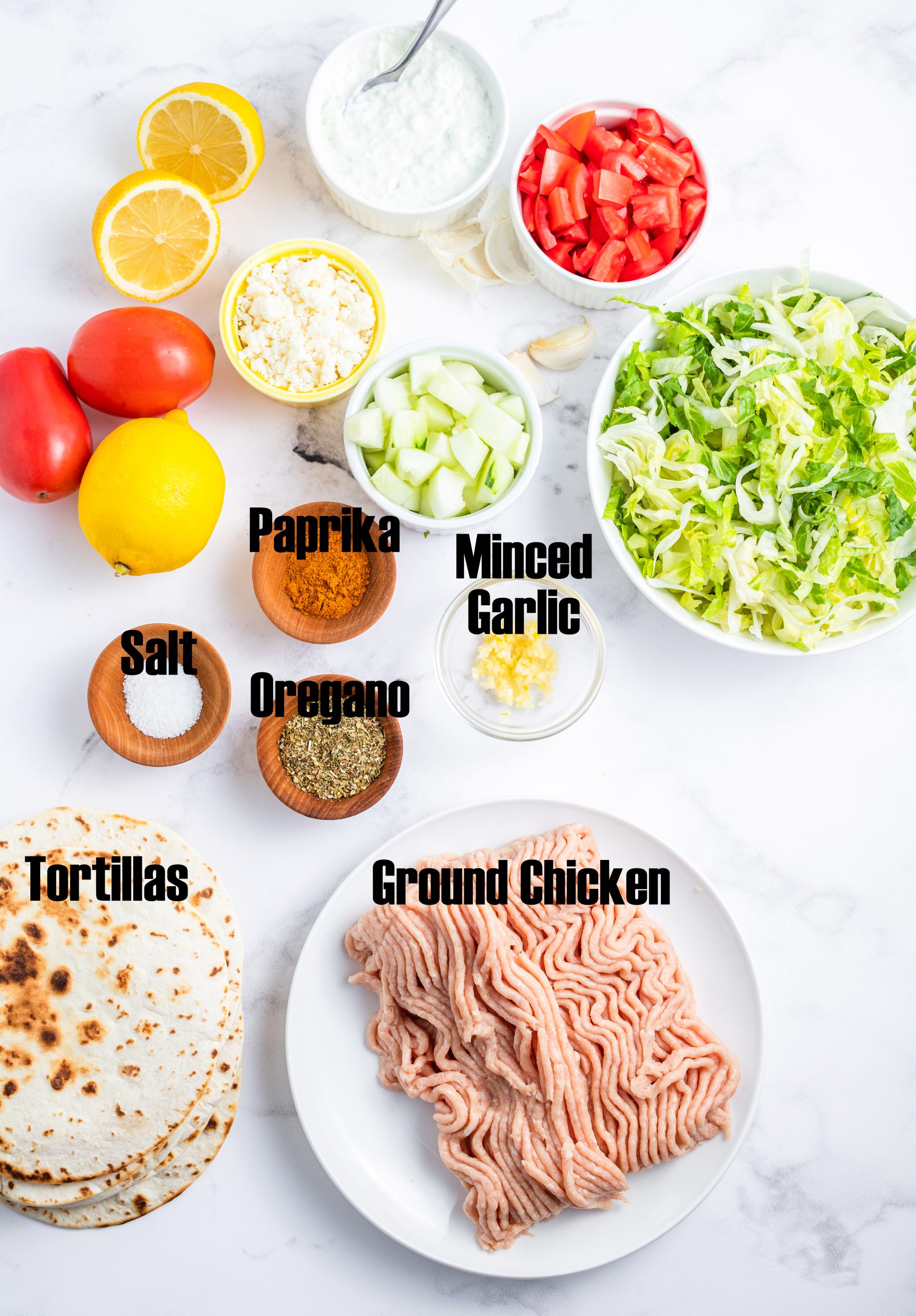 A photo of the ingredients needed to make Greek Chicken Tacos with labels on the ingredients. 