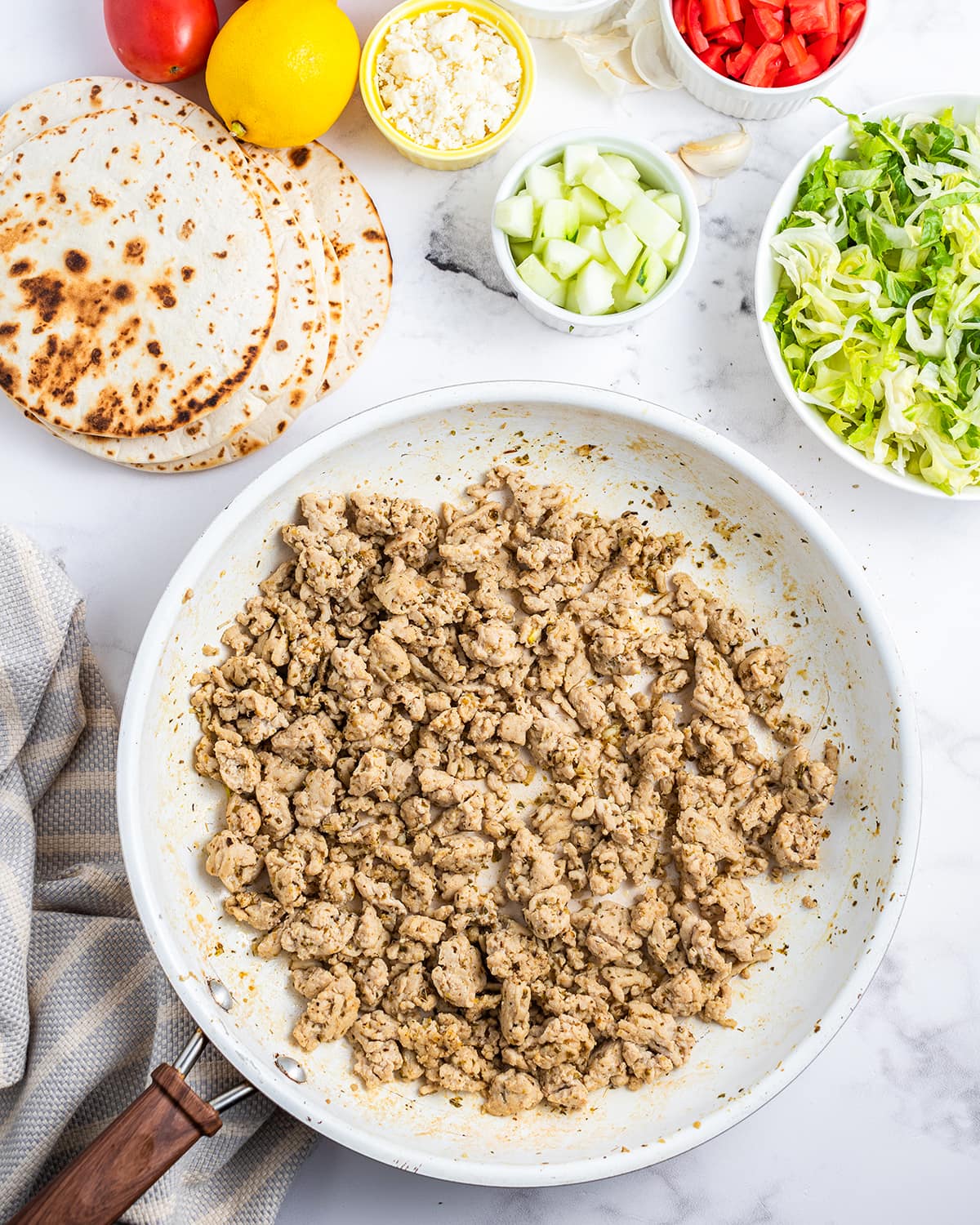 A saute pan of cooked ground chicken.