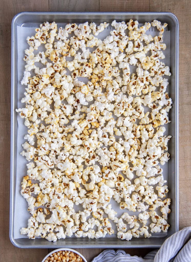 An above view of popped kettle corn on a baking tray.