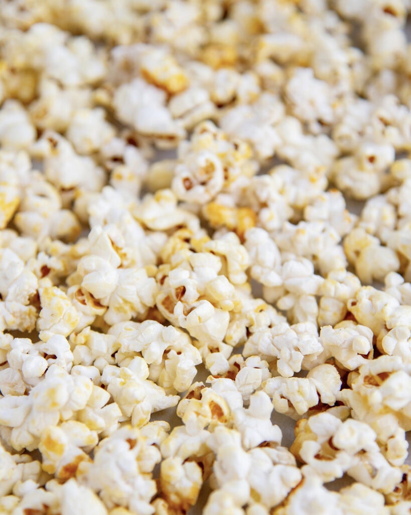 A close up of kettle corn on a baking sheet.