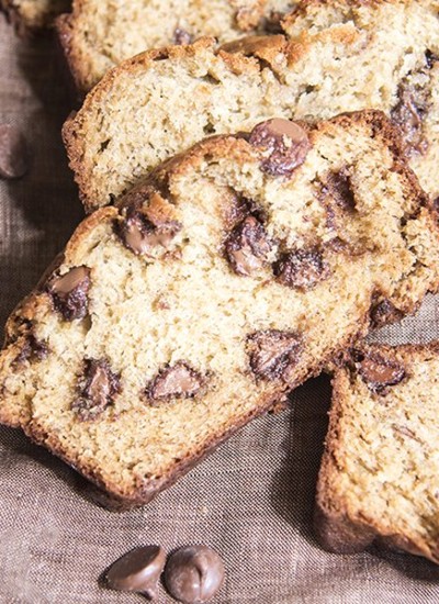 Close up view of chocolate chip banana bread on a brown backdrop.