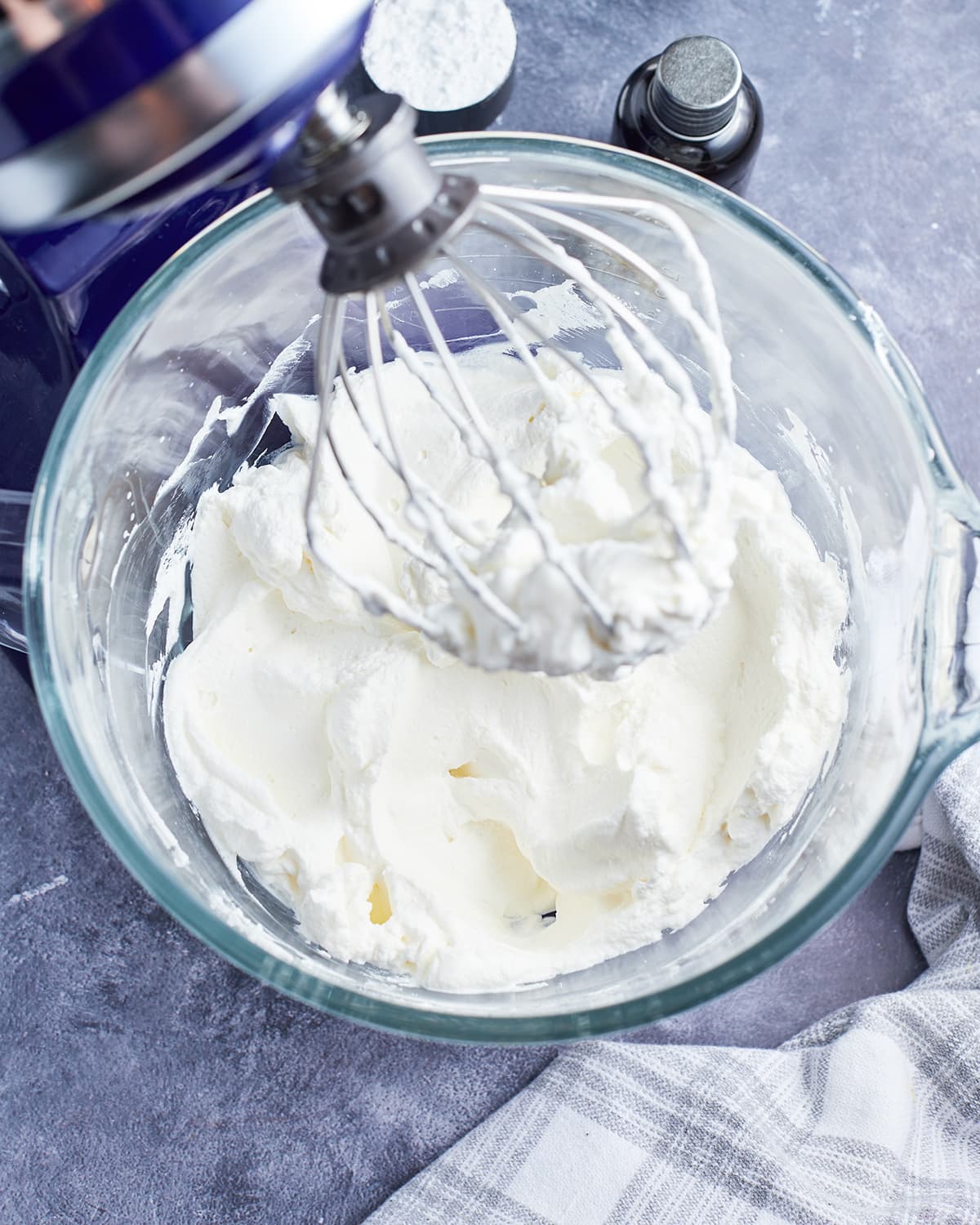 An overhead photo of a stand mixer or whipped cream with a whisk attachment in it.
