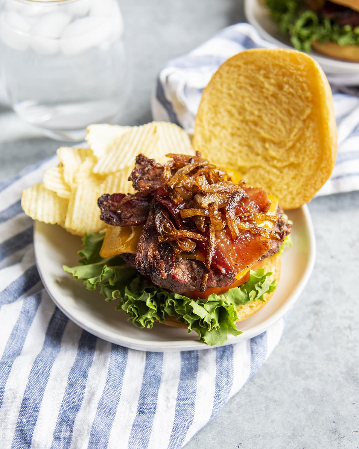 An open faced burger topped with brown sugar bacon and sauteed onions.