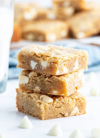 A stack of three white chocolate chip blondies.