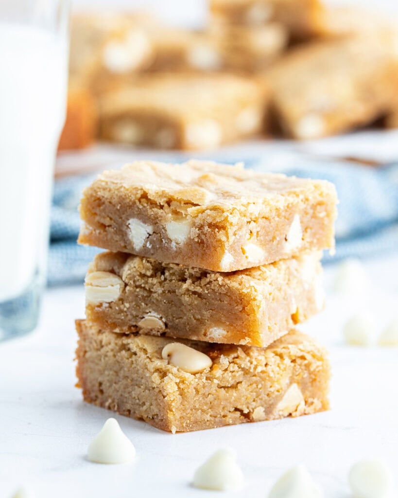 A stack of three white chocolate chip blondies.