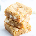 A stack of three white chocolate chip blondies.