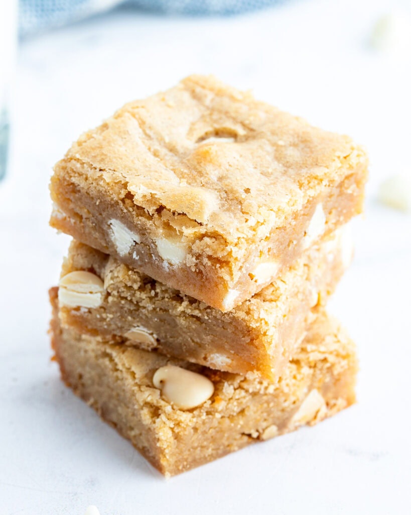 A stack of three white chocolate chip blondies.