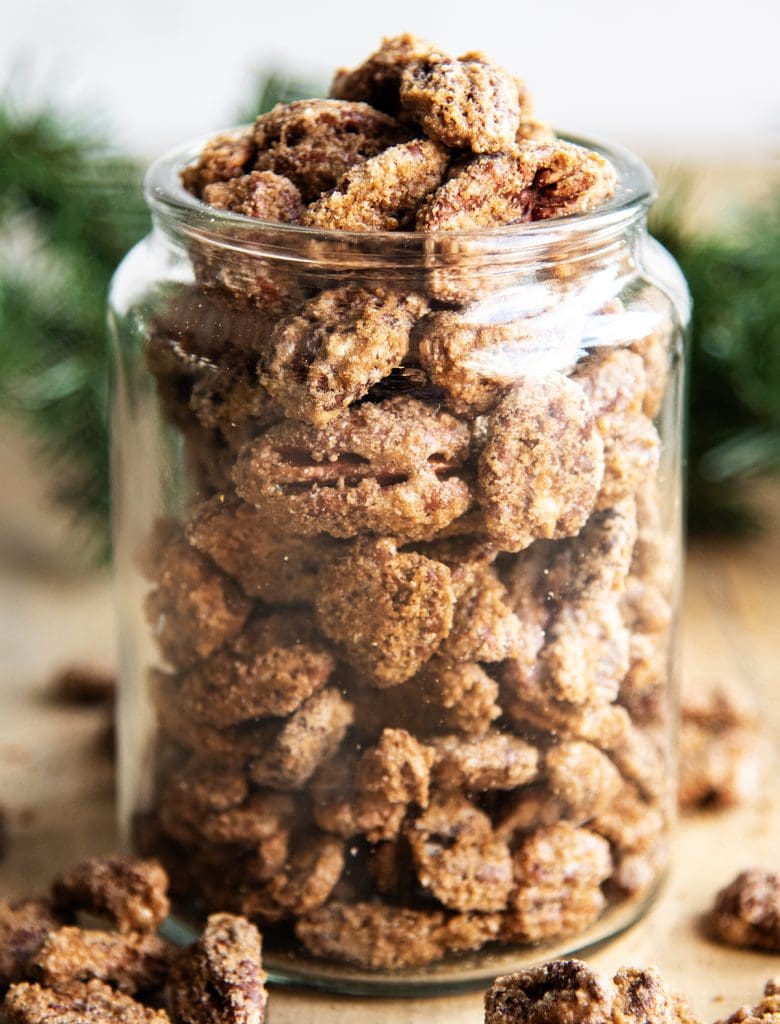 A glass jar full of cinnamon candied pecans.