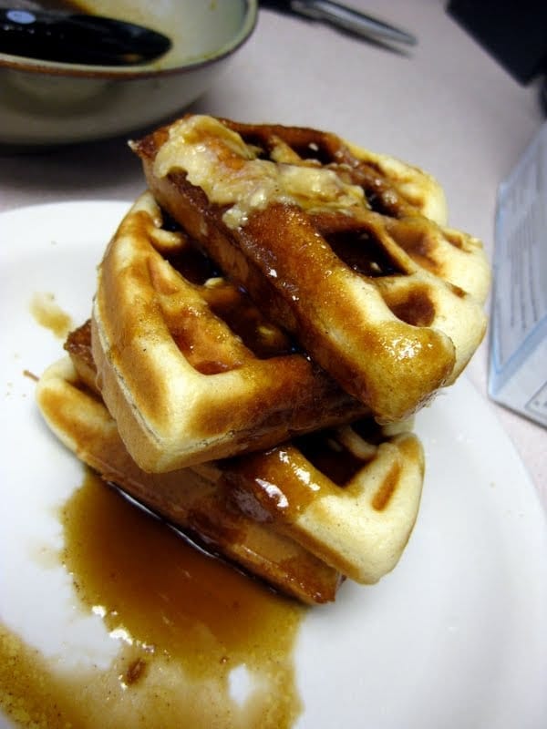 A stack of four pieces of cinnamon roll waffles.
