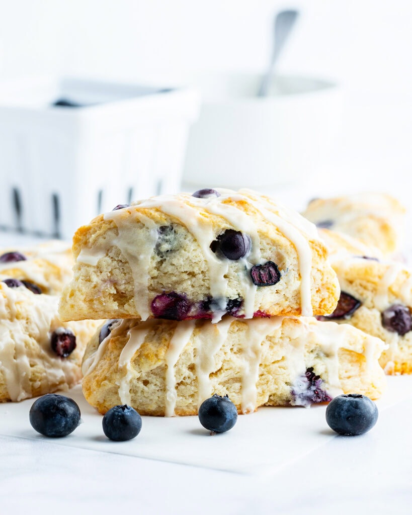 Two blueberry scones stacked on each other and topped with a vanilla galze.