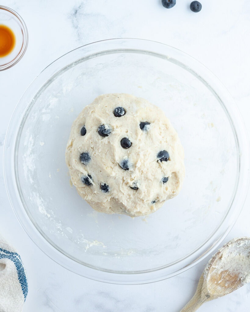 A soft, sticky dough full of blueberries in a bowl.