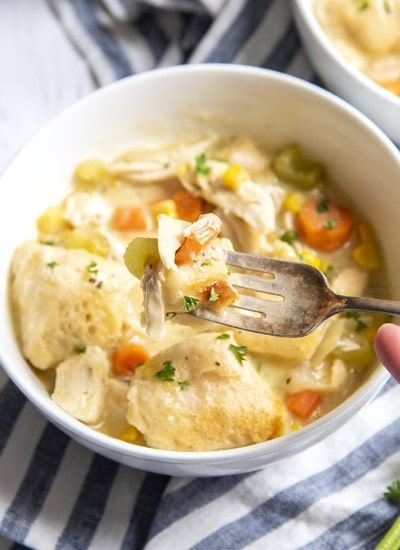 A close up of chicken and dumplings on a fork.