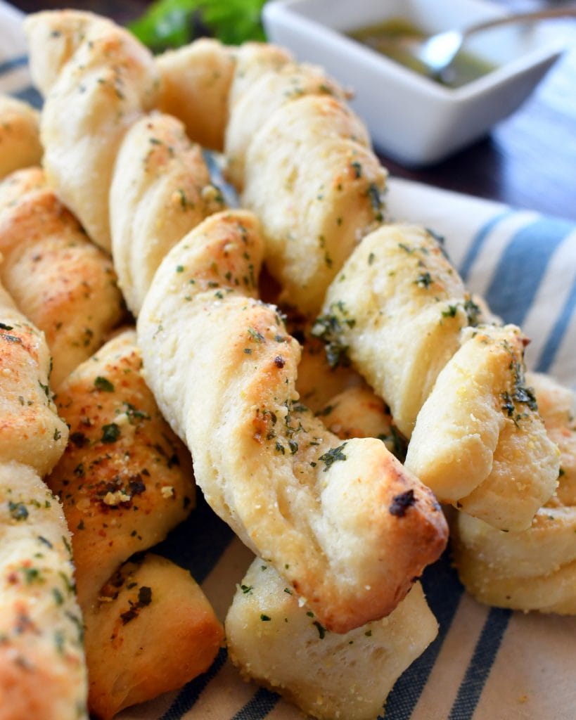 Garlic and Parmesan cheese spread with melted butter all over fresh pizza dough for the yummiest and easiest garlic bread sticks you will ever have.