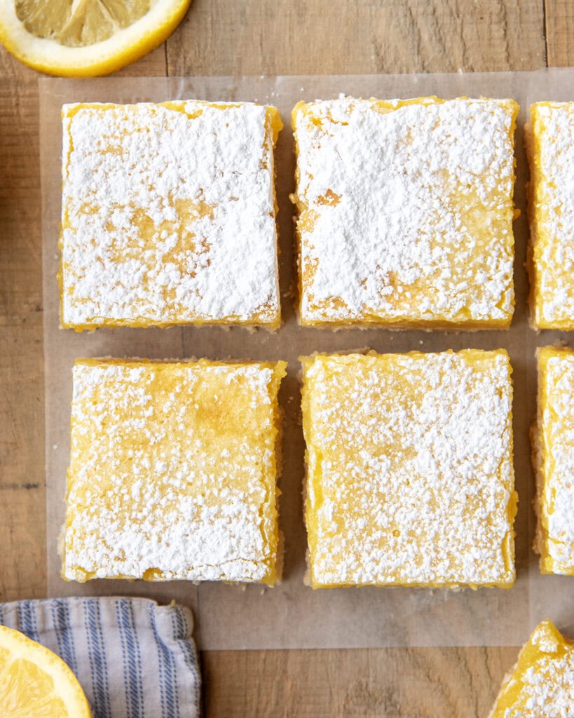 Rows of lemon bar squares with powdered sugar on top of them.