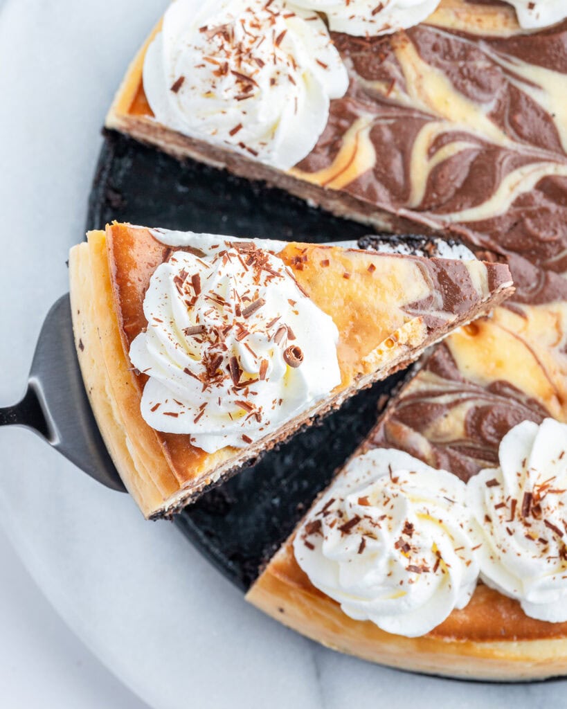 A slice of cheesecake being lifted out of the pan.
