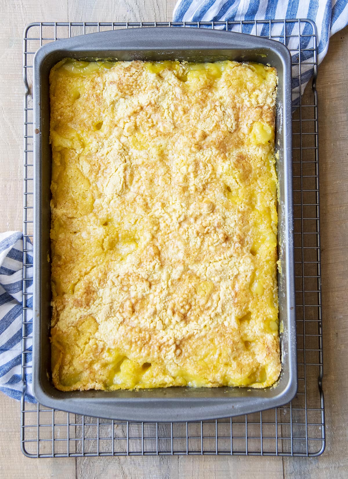 A baking pan of pineapple cobbler from above on a cooling rack.
