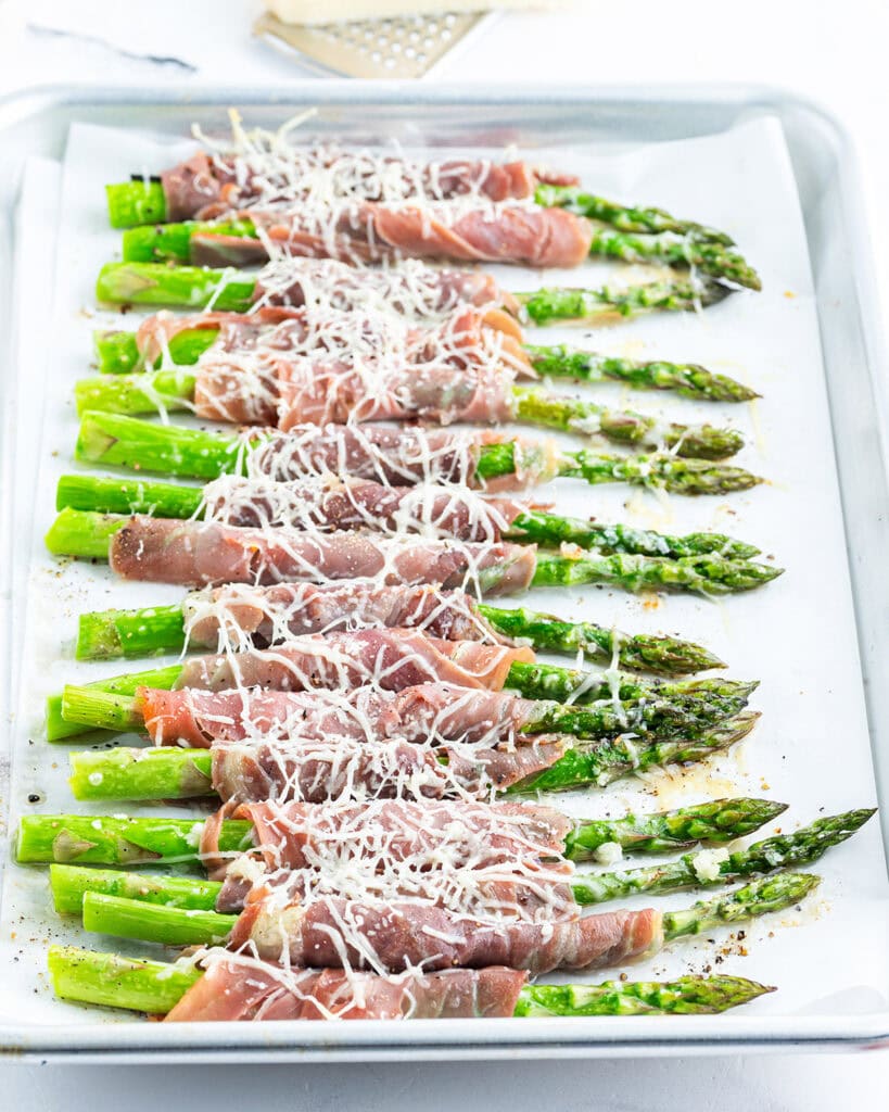 Asparagus stalks wrapped in prosciutto and topped with grated parmesan.