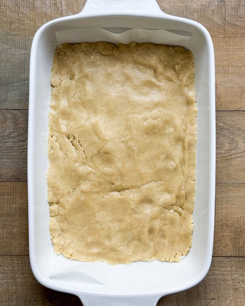 A shortbread crust dough in a baking pan. 