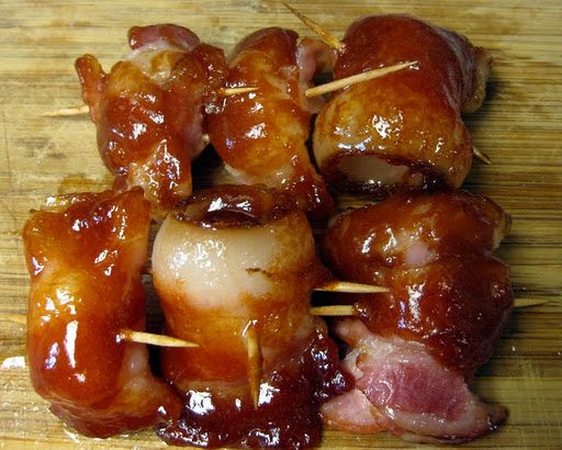 Top view of sweet bacon wrapped pineapple on a wood board.