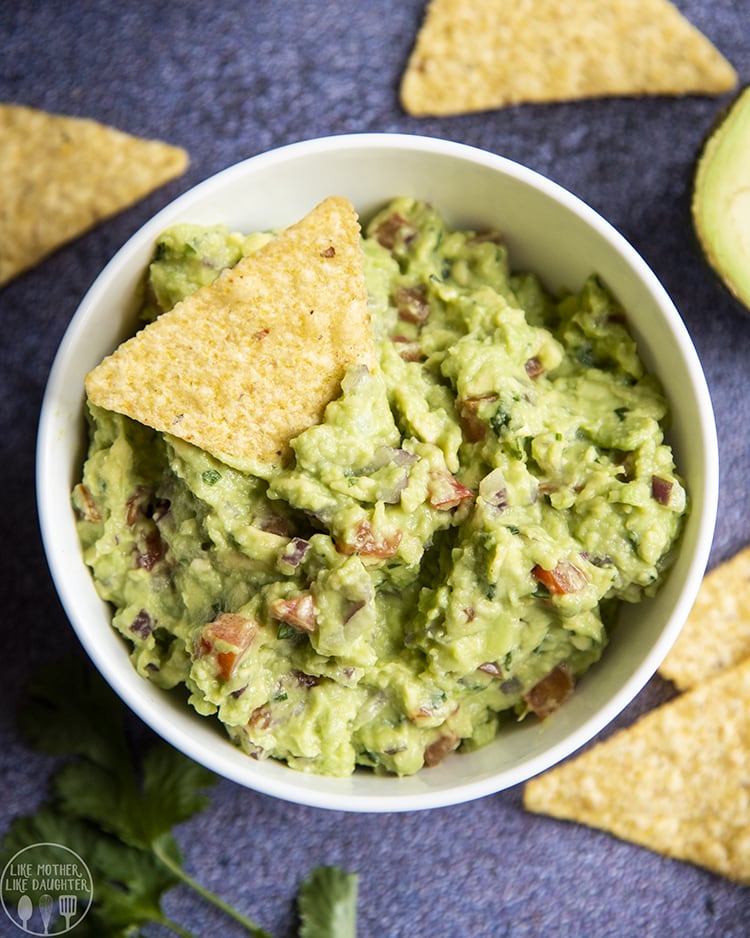 Guacamole in a bowl with a tortilla chip in the middle