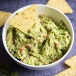 Guacamole in a bowl with a tortilla chip in the middle