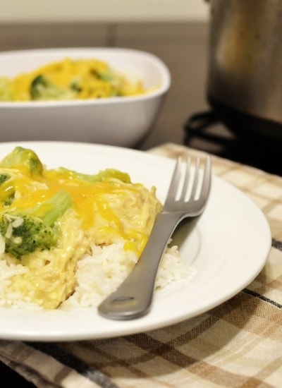 Close up view of creamy chicken and broccoli over rice in a white bowl.