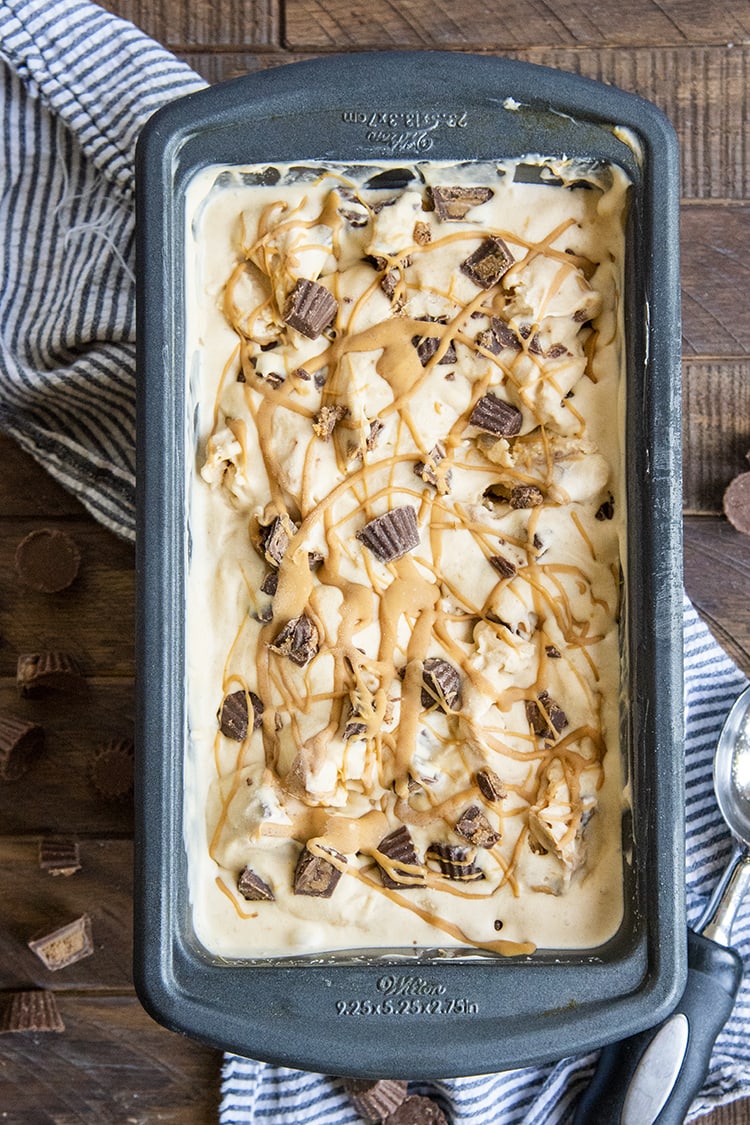 An overhead photo of peanut butter ice cream with chopped up reeses cups. 