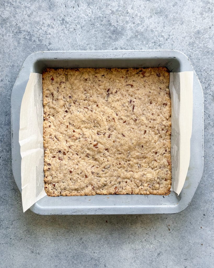 A pecan shortbread crust baked in a pan.