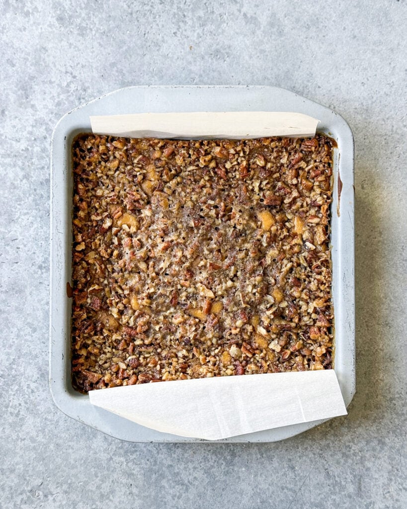 An above view of the crunchy pecan topping on pumpkin cheesecake bars.