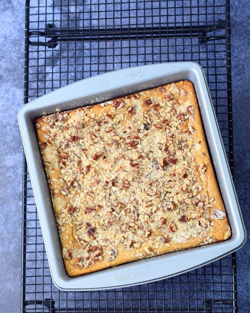 pecan pumpkin cheesecake bars in an 8x8 square pan on a cooling rack