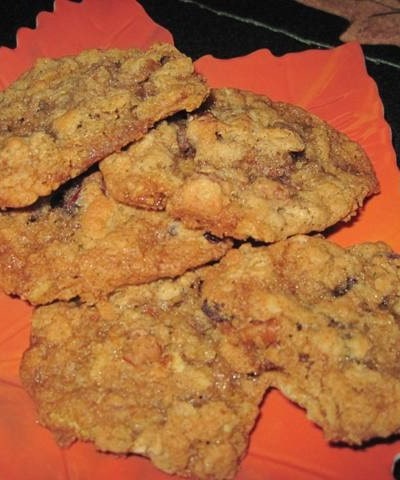 Angled view of oatmeal cranraisin pecan cookies on a orange plate.