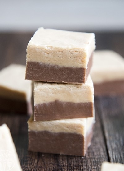 A stack of three pieces of peanut butter and chocolate layered fudge.