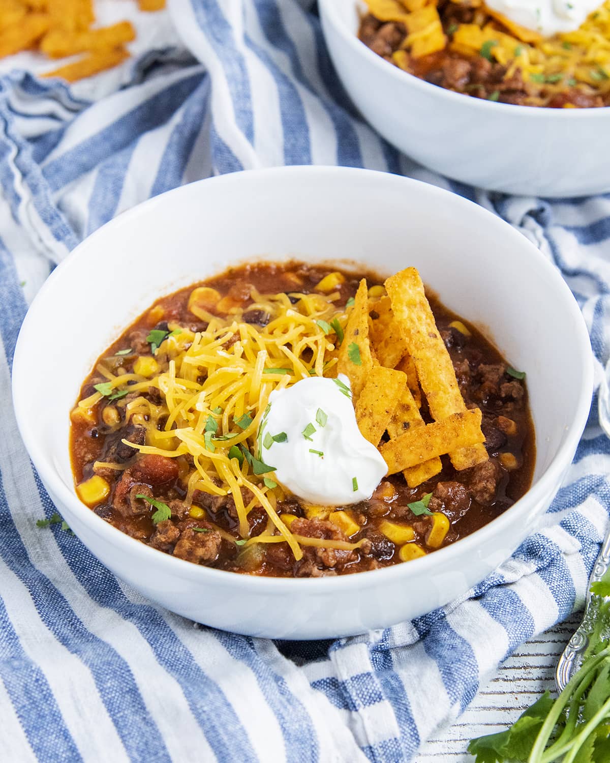 A bowl of taco soup topped with shredded cheese and tortilla strips.