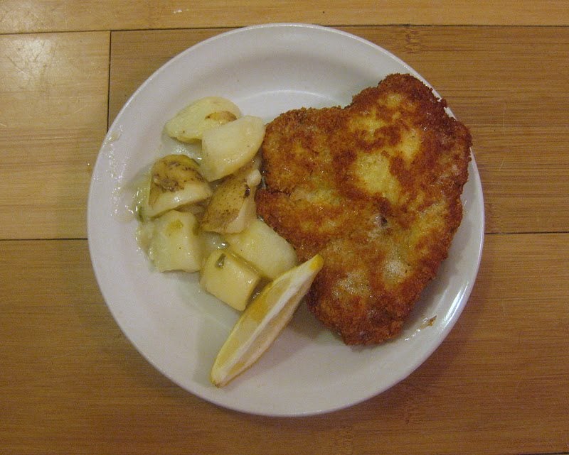 Top view of wiener schnitzel on a white plate.