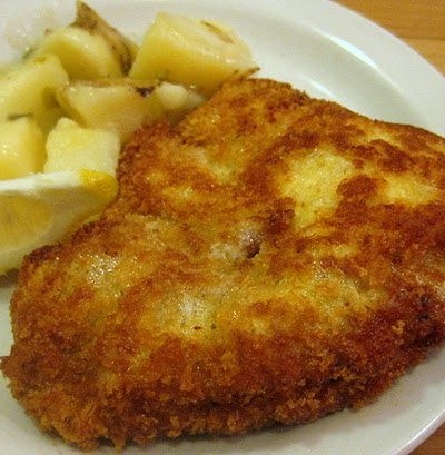 Close up view of wiener schnitzel on a white plate.