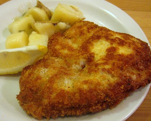 Close up view of wiener schnitzel on a white plate.