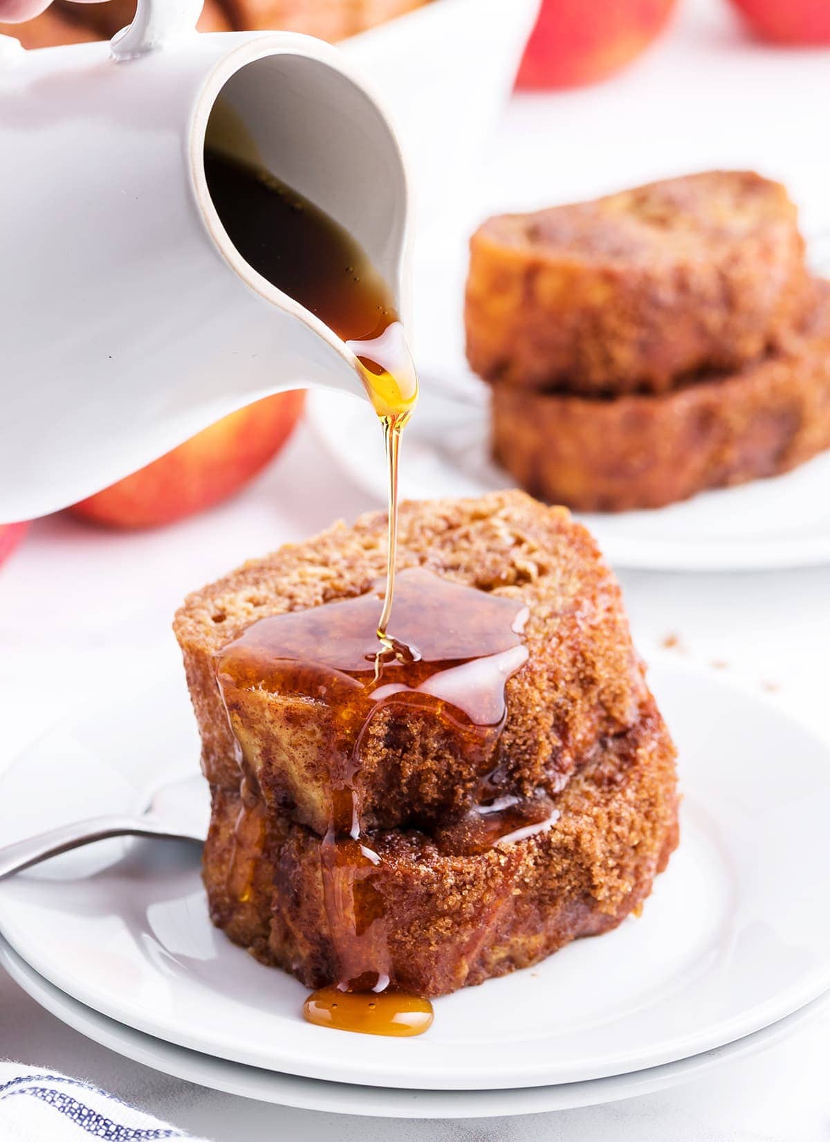 Apple Butter French Toast slices on a plate with syrup being poured over the top.