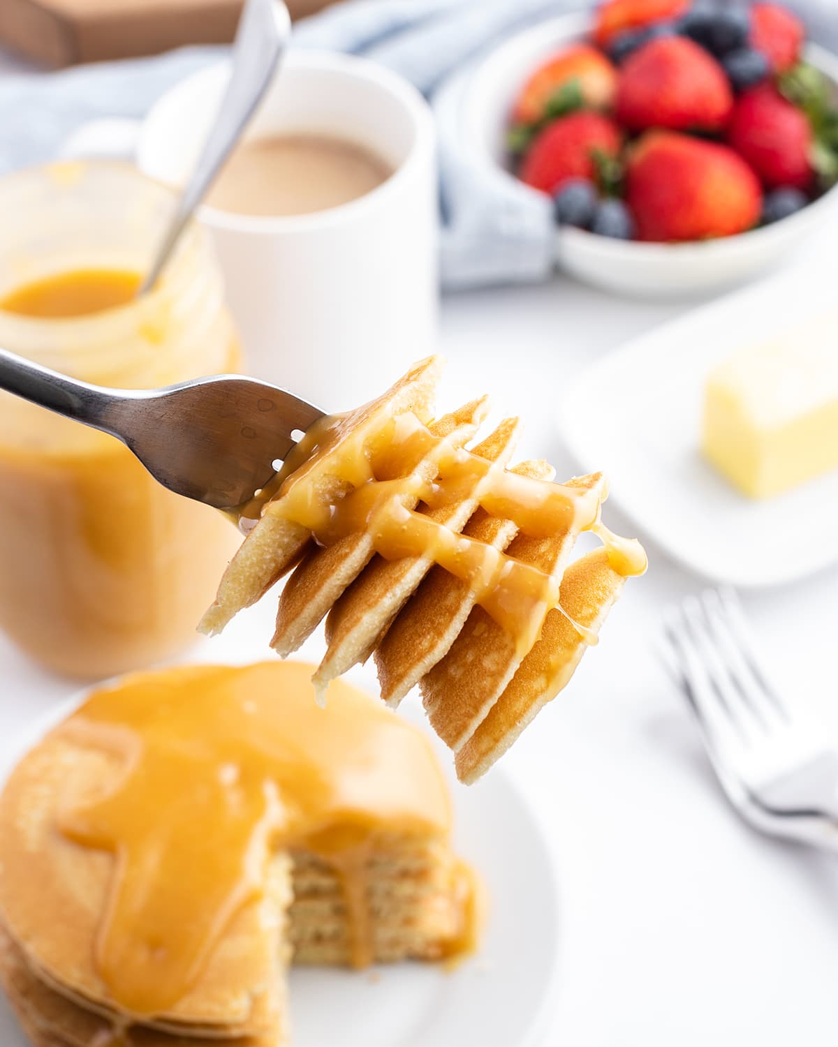 A fork full of pancake bites topped with buttermilk syrup.