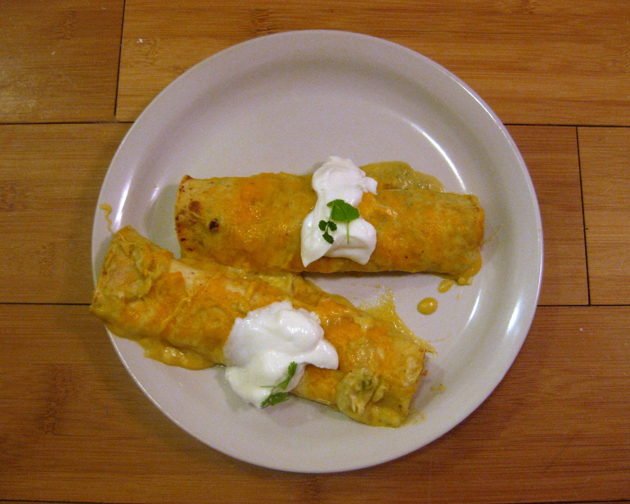 Top view of enchiladas verde on a white plate.