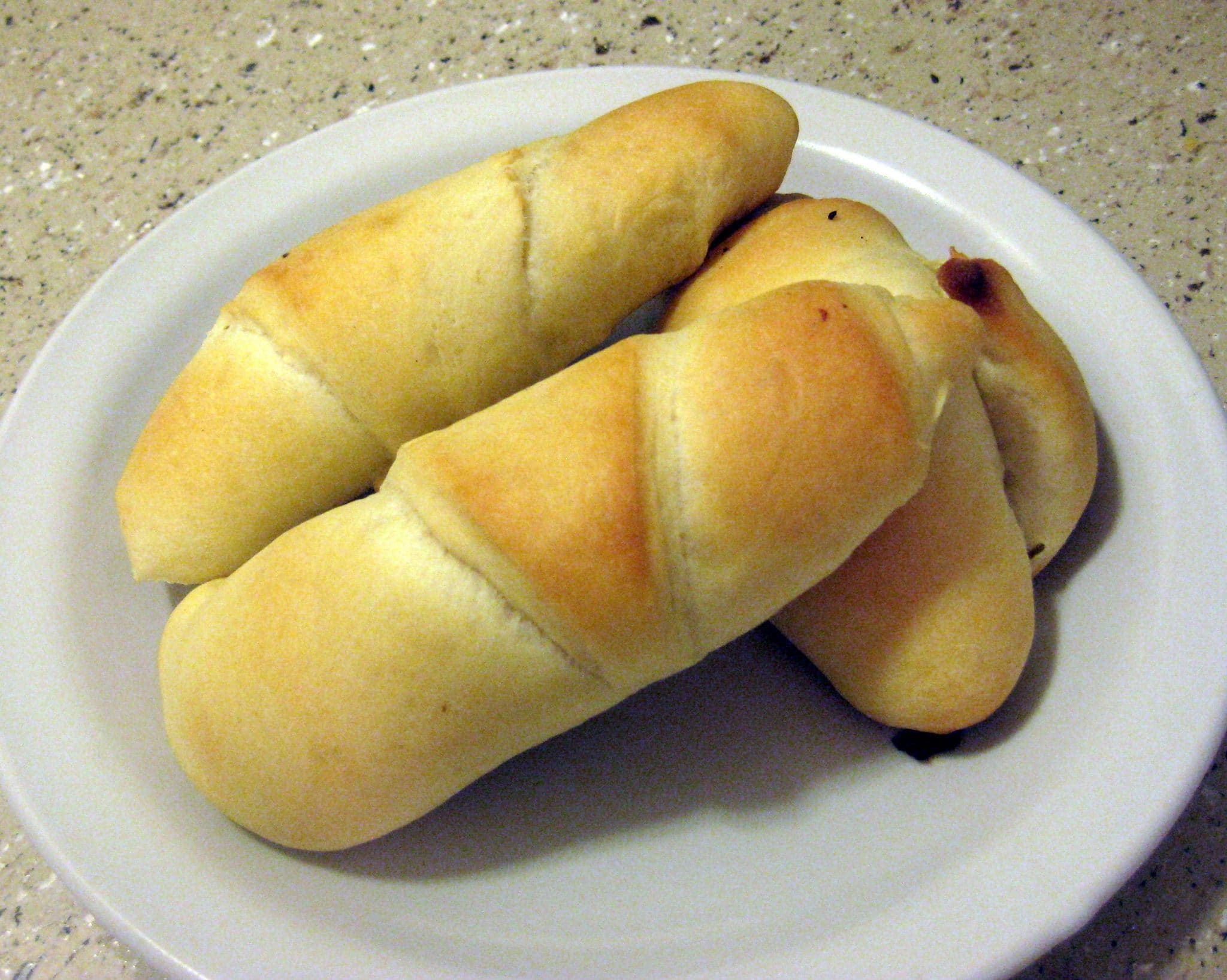 Top view of crescent rolls on a white plate.