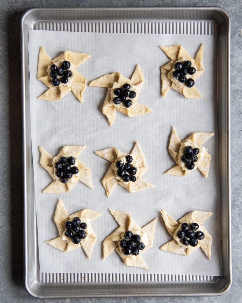 Unbaked Blueberry Danishes on a baking pan.