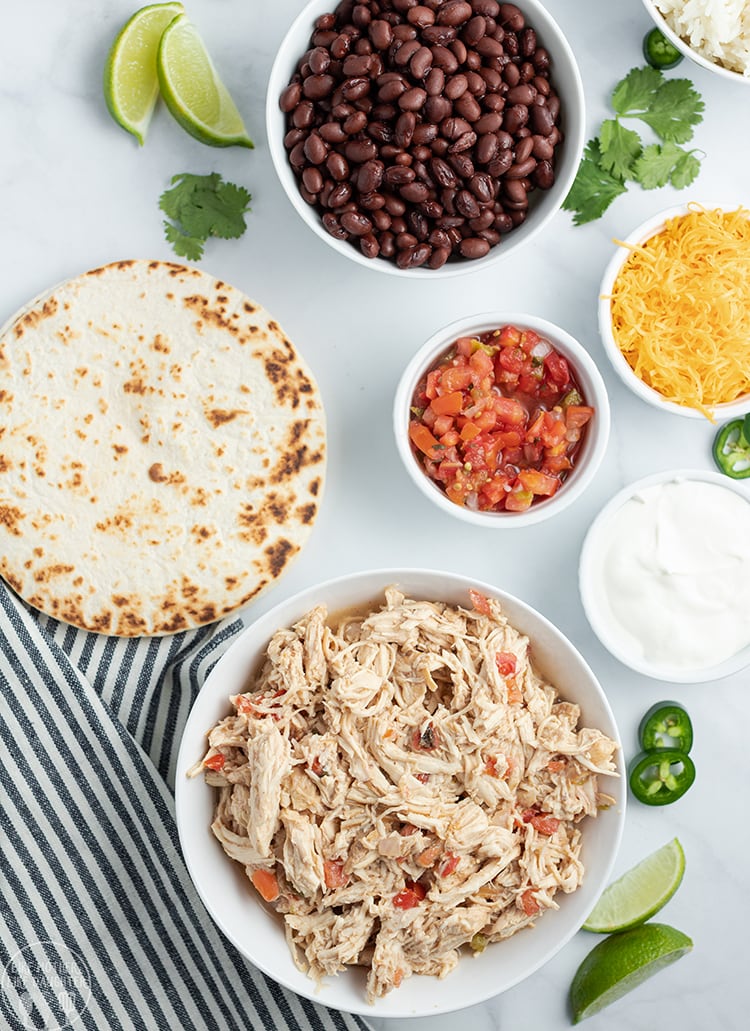 Crockpot Chicken Tacos are perfect with a tortilla and all the taco fixins, black beans, salsa, cheese and more.
