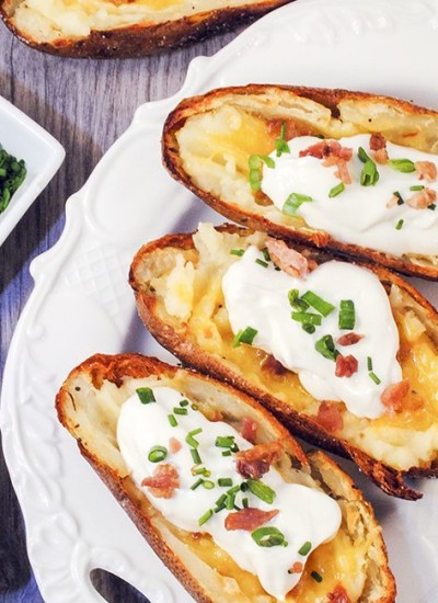 Top view of loaded potato skins on a plate.