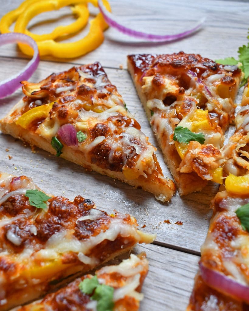 Angled view of bbq chicken pizza on a wood board.