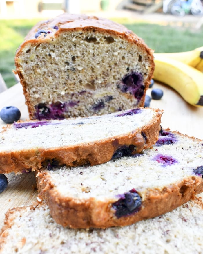 Slices of blueberry banana bread cut off the front of the loaf. 