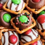 A close up of a pile of Christmas pretzel treats, with square snap pretzels, and topped with a green m&m and sprinkles.