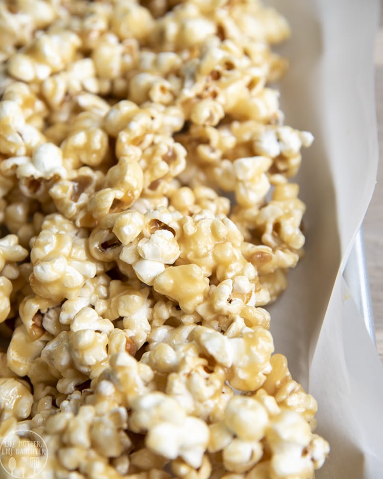 Gooey caramel popcorn in a white bowl